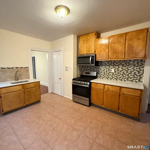 a kitchen with stainless steel appliances a stove sink and cabinets