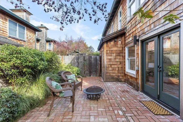 a patio with a table and chairs and potted plants