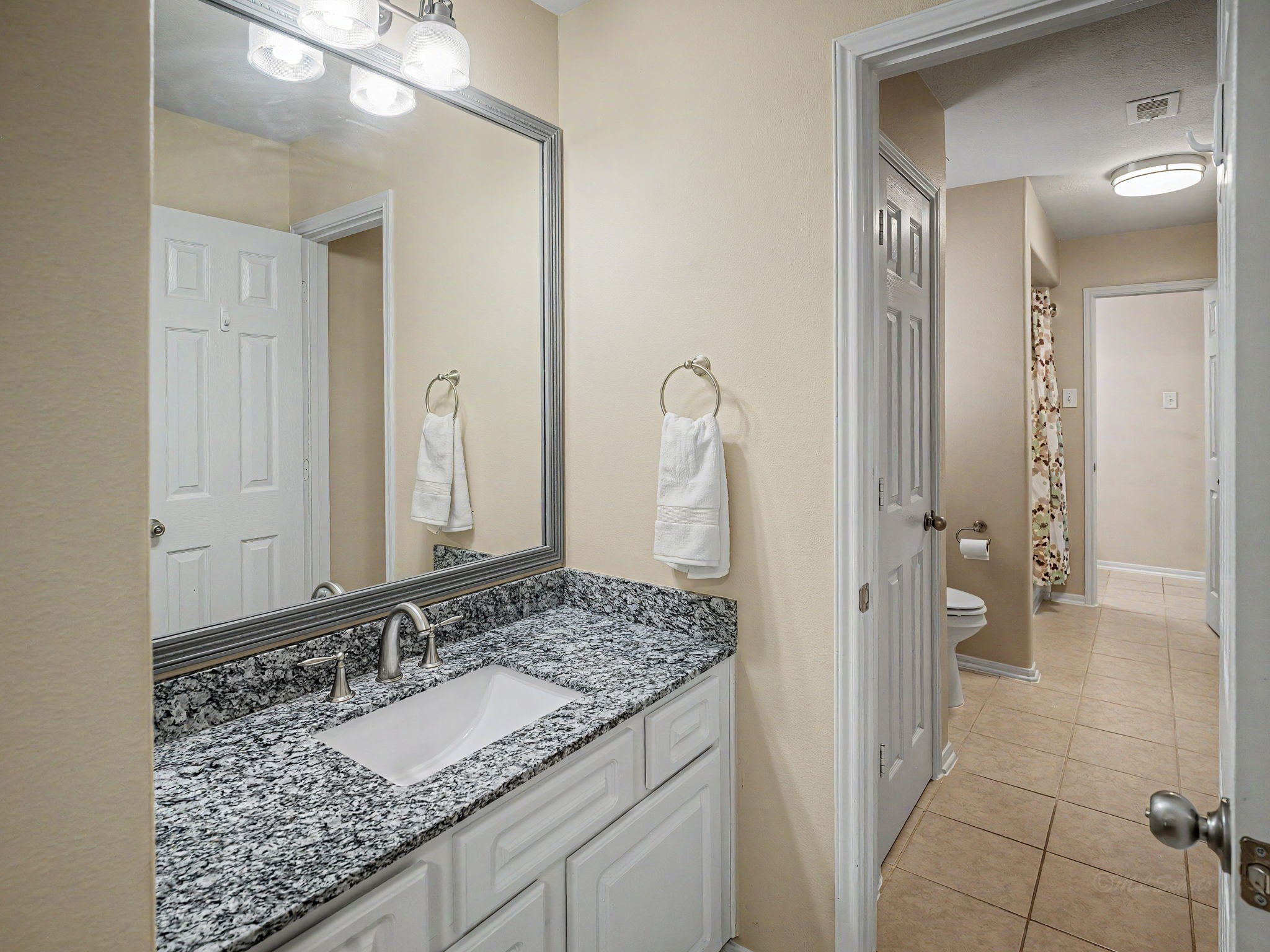 2210 Fox Path Katy, TX 77494 - Photo 34 of 47 The single vanity features a premium under-mount sink set into a gorgeous, highly detailed blue-and-gray granite countertop. White cabinetry underneath offers ample storage for towels and toiletries, while modern brushed-nickel fixtures complete the look.