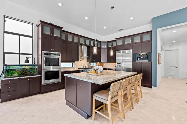 a kitchen with stainless steel appliances granite countertop a stove and a view of living room