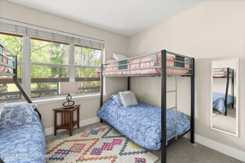 a bedroom with a bed and large windows