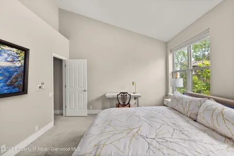 a bedroom with a bed and a large window