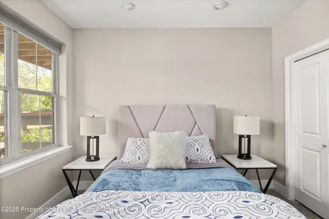 a bed sitting in a bedroom next to a window