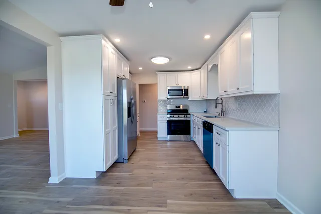 a kitchen with stainless steel appliances granite countertop a refrigerator and a stove top oven