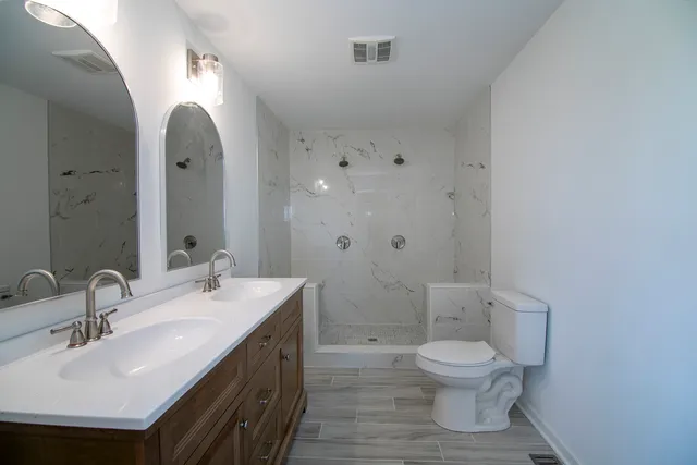 a bathroom with a sink a toilet and shower