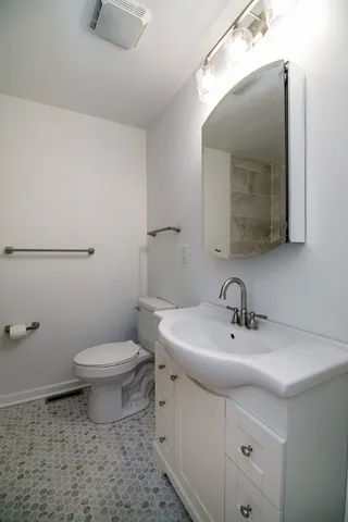 a bathroom with a toilet sink and mirror