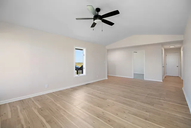 a view of empty room with wooden floor and ceiling fan