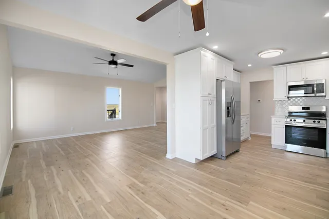 a view of kitchen with sink and refrigerator