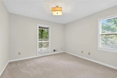 an empty room with closet and a chandelier fan