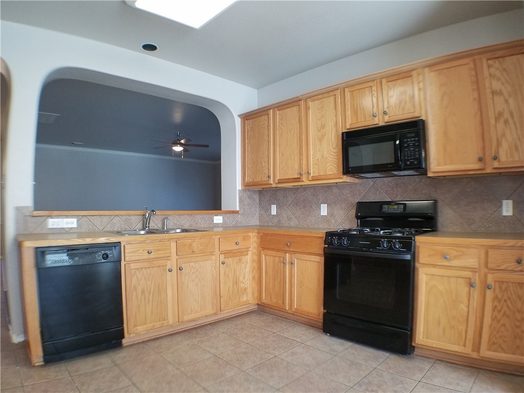 2208 Hayfield Square Pflugerville, TX 78660 - Photo 12 of 29 a kitchen with granite countertop a stove top oven microwave and cabinets
