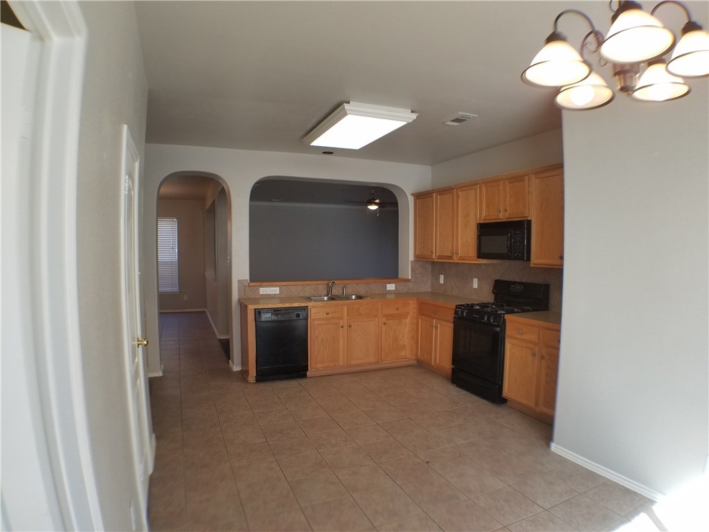 2208 Hayfield Square Pflugerville, TX 78660 - Photo 14 of 29 a large kitchen with a sink and stainless steel appliances