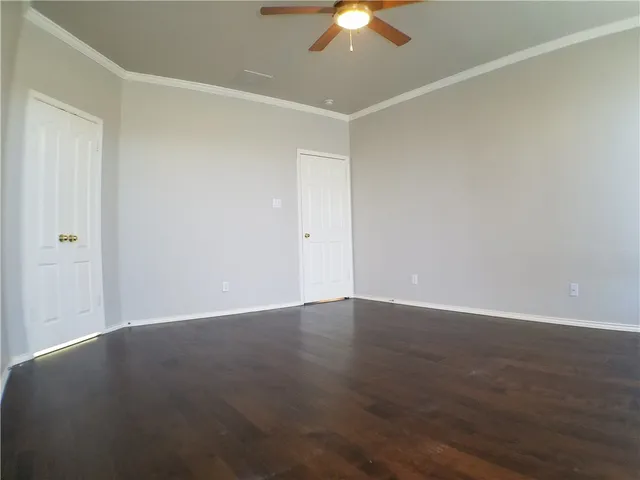 an empty room with a ceiling fan and a window