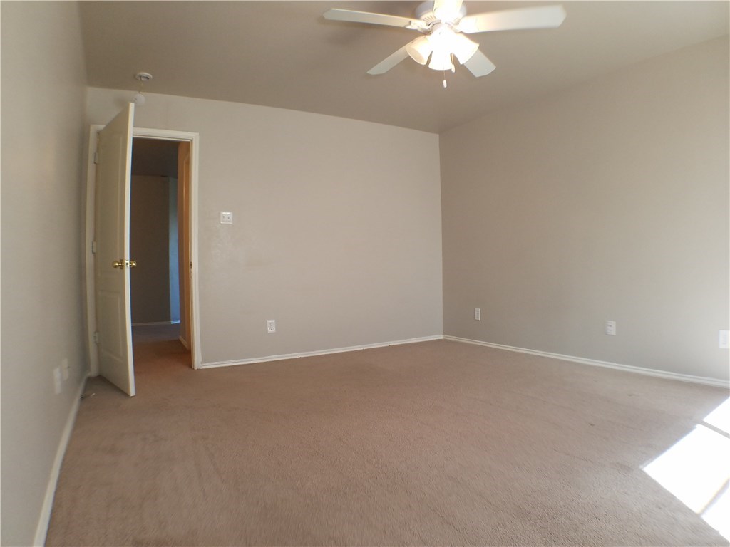 2208 Hayfield Square Pflugerville, TX 78660 - Photo 22 of 29 an empty room with a chandelier fan and windows