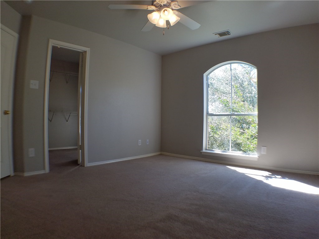 2208 Hayfield Square Pflugerville, TX 78660 - Photo 25 of 29 an empty room with a window and a chandelier fan