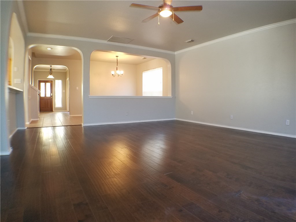 2208 Hayfield Square Pflugerville, TX 78660 - Photo 4 of 29 an empty room with wooden floor and windows