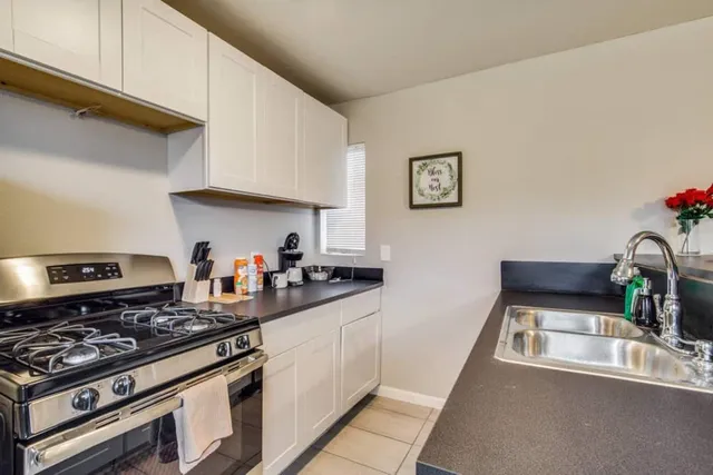 a kitchen with stainless steel appliances a white stove top oven and sink