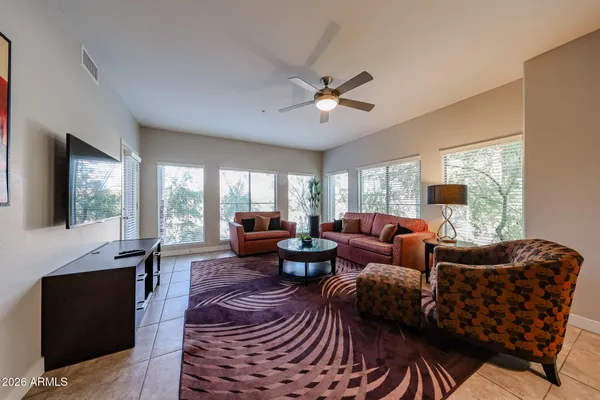 a living room with furniture fireplace and a large window