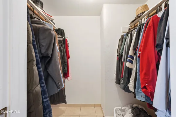 a view of walk in closet with clothes and shoes