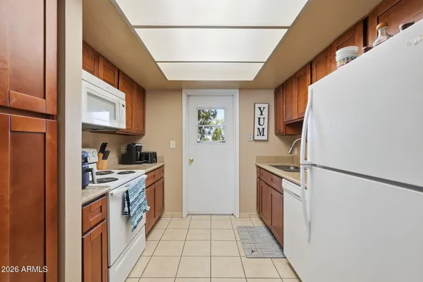 a kitchen with stainless steel appliances granite countertop a refrigerator a stove and a sink