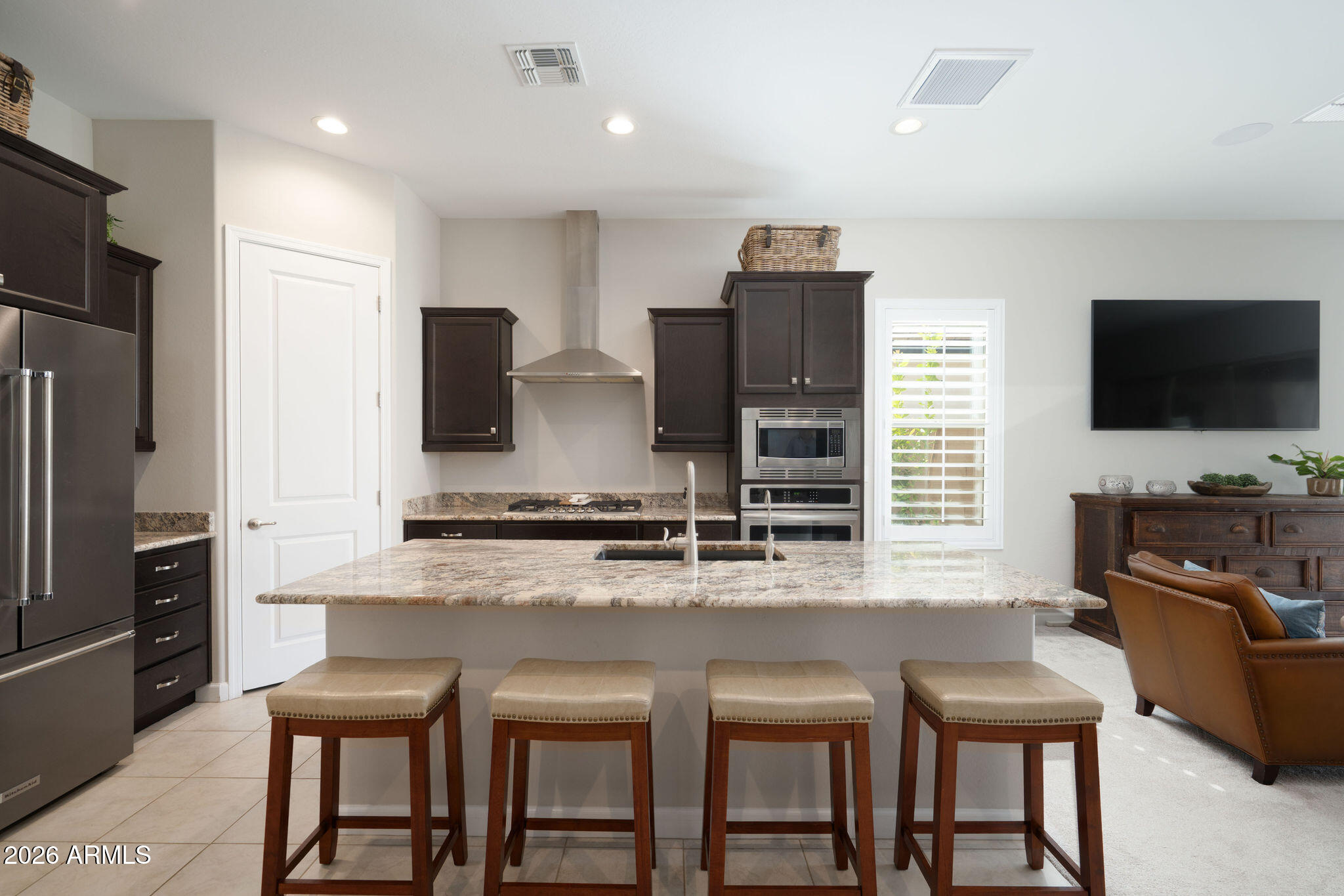 18236 North 66th Way Phoenix, AZ 85054 - Photo 4 of 17 a kitchen with stainless steel appliances granite countertop a stove top oven a refrigerator a sink and chairs