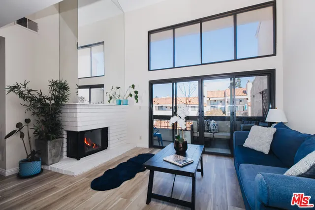 a living room with furniture a fireplace and a potted plant