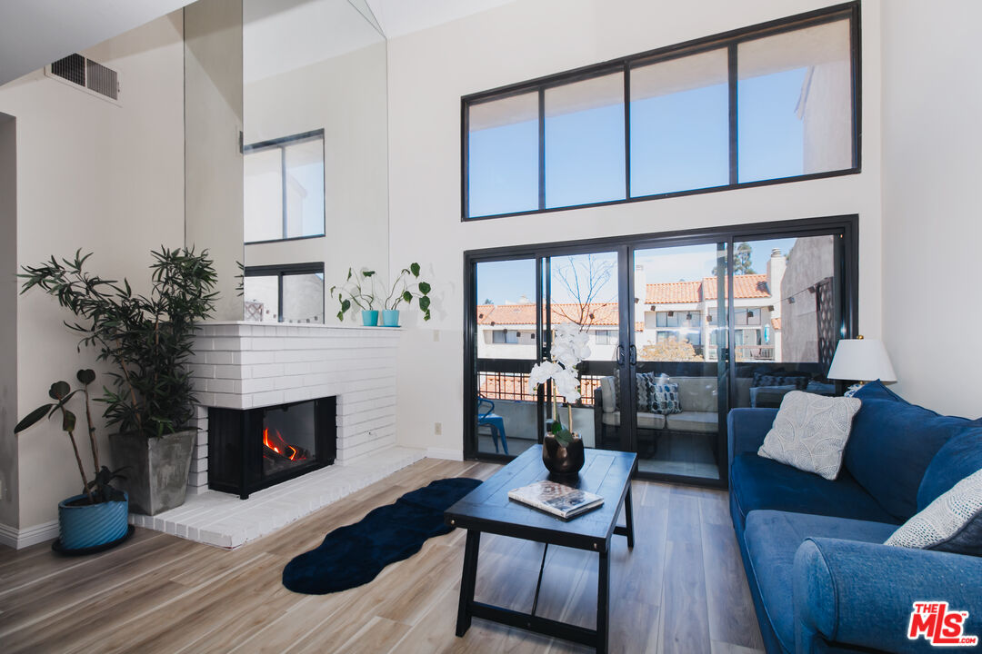 a living room with furniture a fireplace and a potted plant