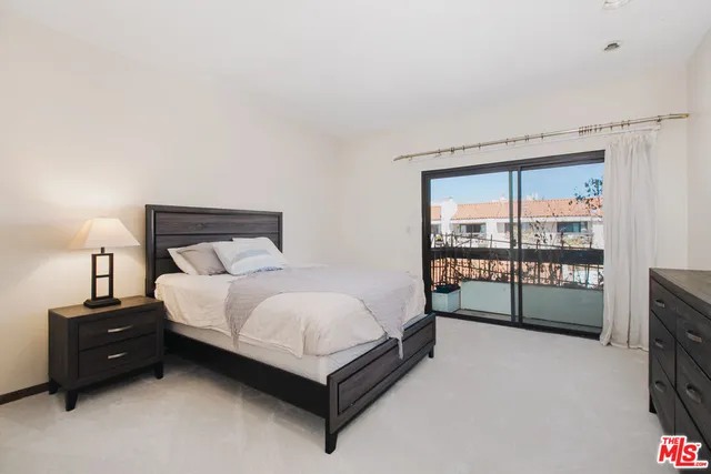 a spacious bedroom with a bed and a tv