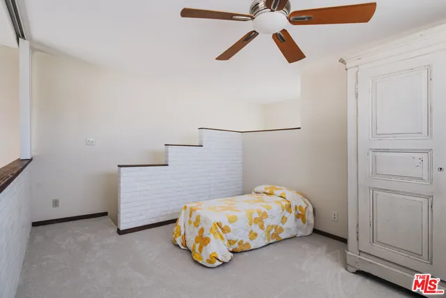 a bedroom with a bed and a ceiling fan