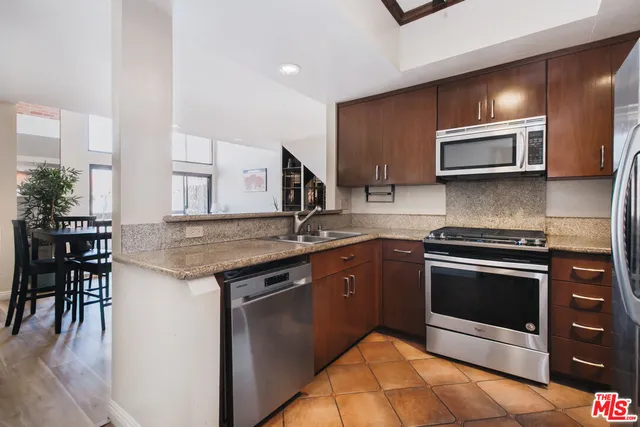 a kitchen with stainless steel appliances granite countertop a stove a microwave and a sink