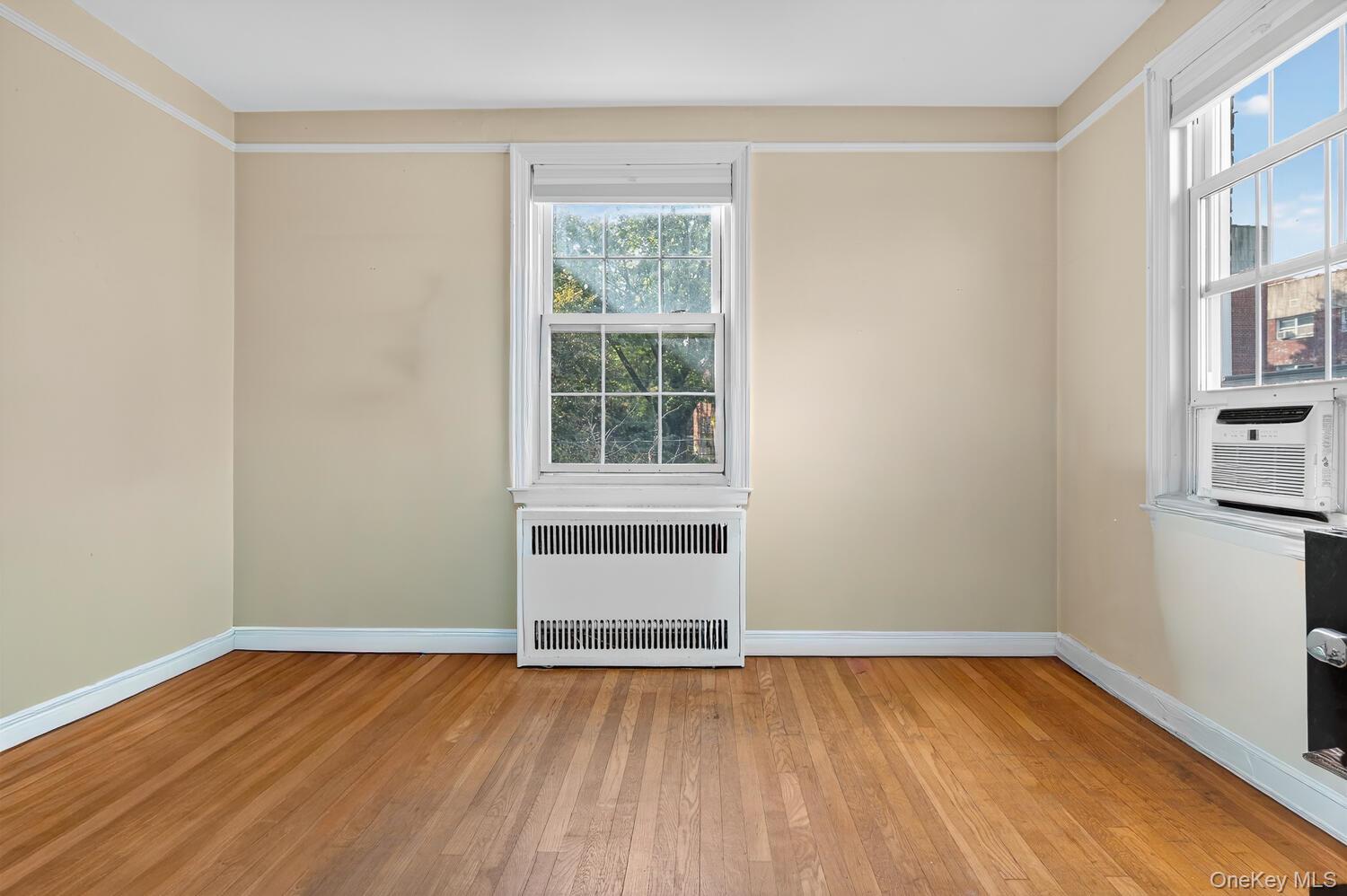 8 Welwyn Road, Unit 3F Great Neck, NY 11021 - Photo 12 of 17 Spare room with radiator heating unit, light wood-type flooring, and cooling unit