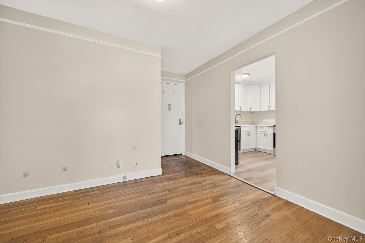 8 Welwyn Road, Unit 3F Great Neck, NY 11021 - Photo 4 of 17 Unfurnished room with light wood finished floors and ornamental molding