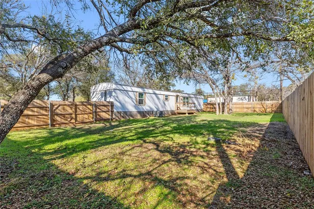 a view of a backyard with table and chairs and wooden fence