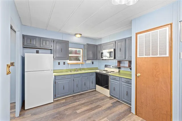 a kitchen with refrigerator cabinets and wooden floor