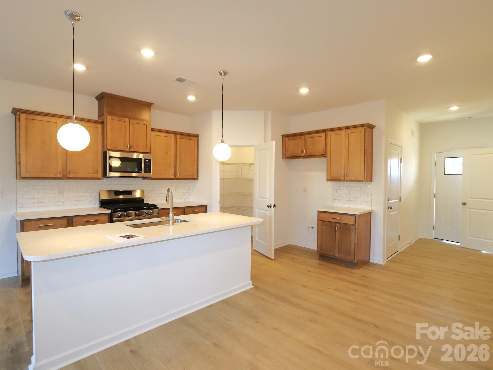 1110 Overbrook Place Wingate, NC 28174 - Photo 3 of 21 a large kitchen with a large counter top a sink stainless steel appliances and cabinets