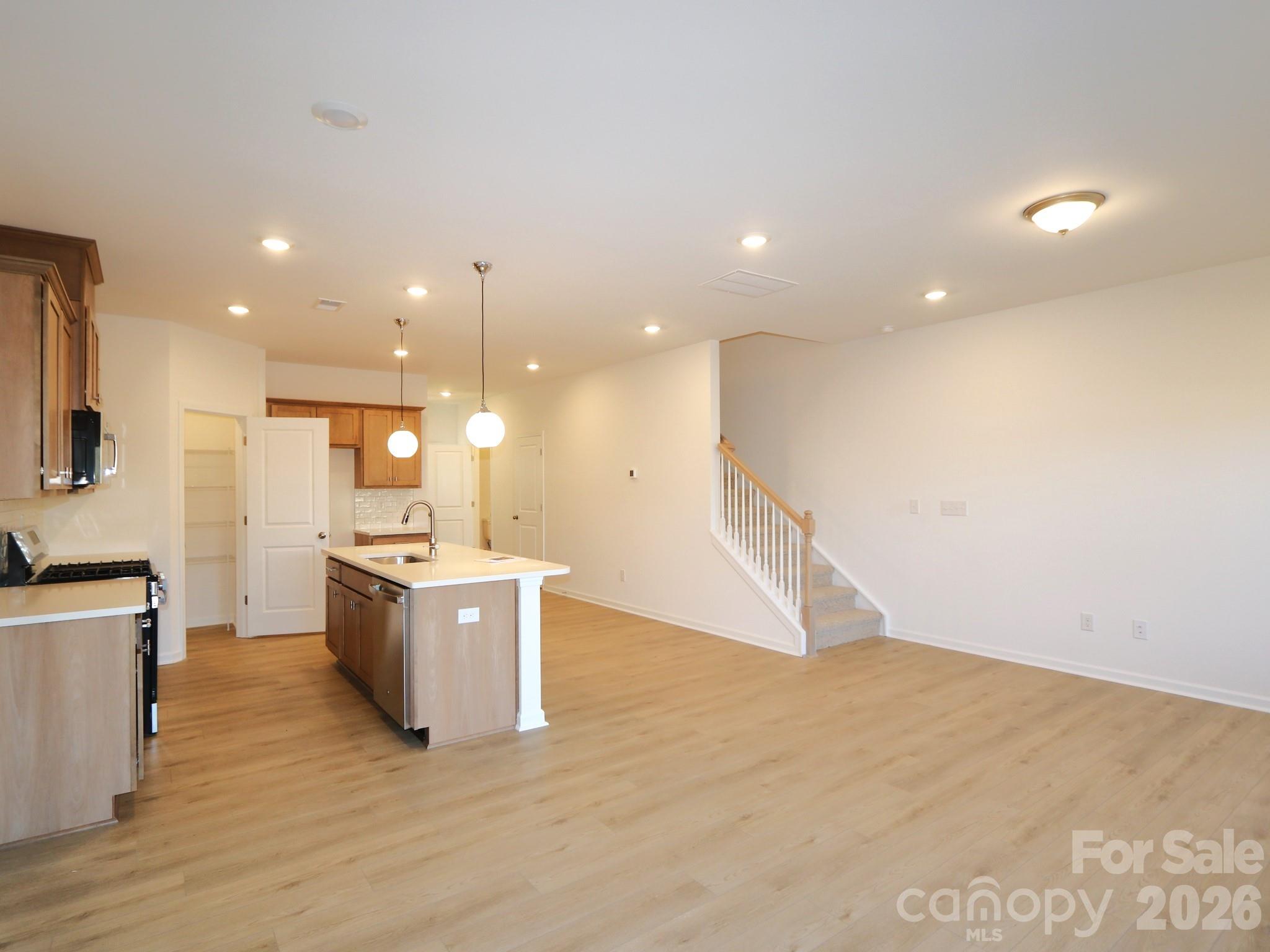 1110 Overbrook Place Wingate, NC 28174 - Photo 7 of 21 a large kitchen with a wooden floor and a sink