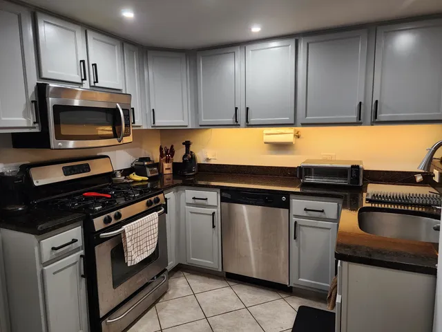 a kitchen with granite countertop cabinets stainless steel appliances and a sink