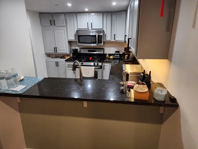 a kitchen with a sink a stove and chairs