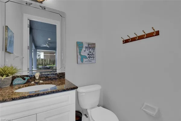 a bathroom with a granite countertop sink mirror vanity and toilet
