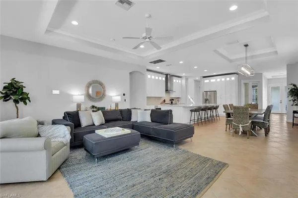 a living room with furniture kitchen view and a potted plant