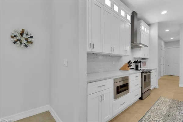 a kitchen with granite countertop white cabinets and white appliances