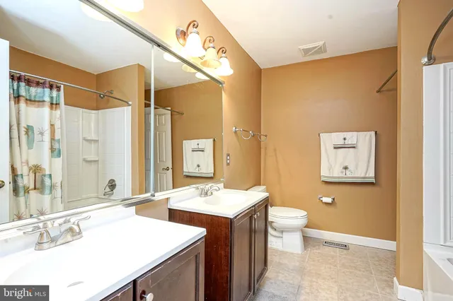 a bathroom with a sink a toilet a mirror and shower