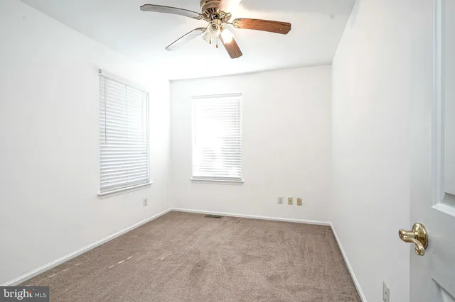 an empty room with chandelier fan