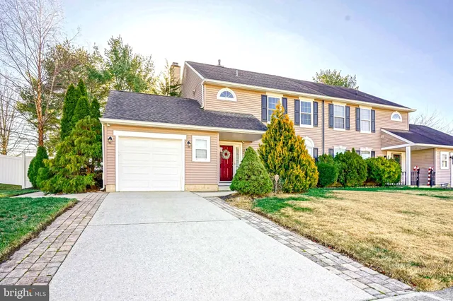 a front view of a house with a yard and potted plants