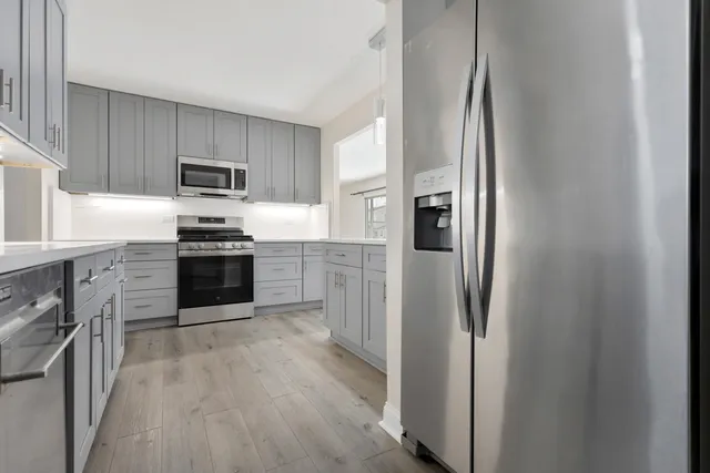 a kitchen with stainless steel appliances granite countertop a refrigerator and a sink