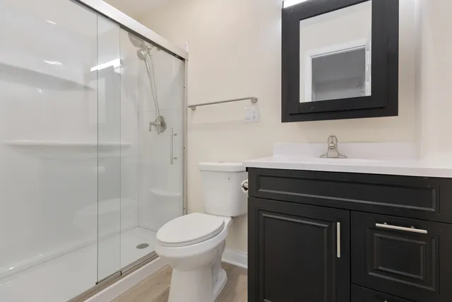 a bathroom with a sink a toilet and shower