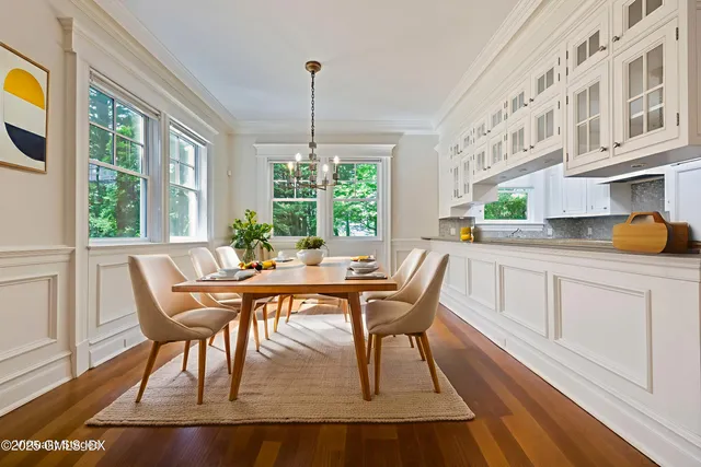 a dining room with furniture a chandelier and wooden floor
