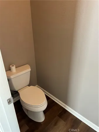 a white toilet sitting next to a white wall