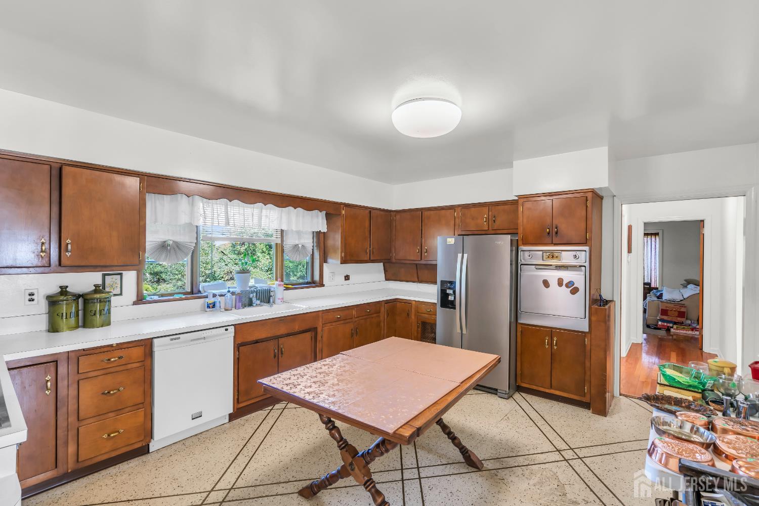16 Stafford Road Colonia, NJ 07067 - Photo 13 of 41 a kitchen with a refrigerator a sink dishwasher with a dining table and chairs