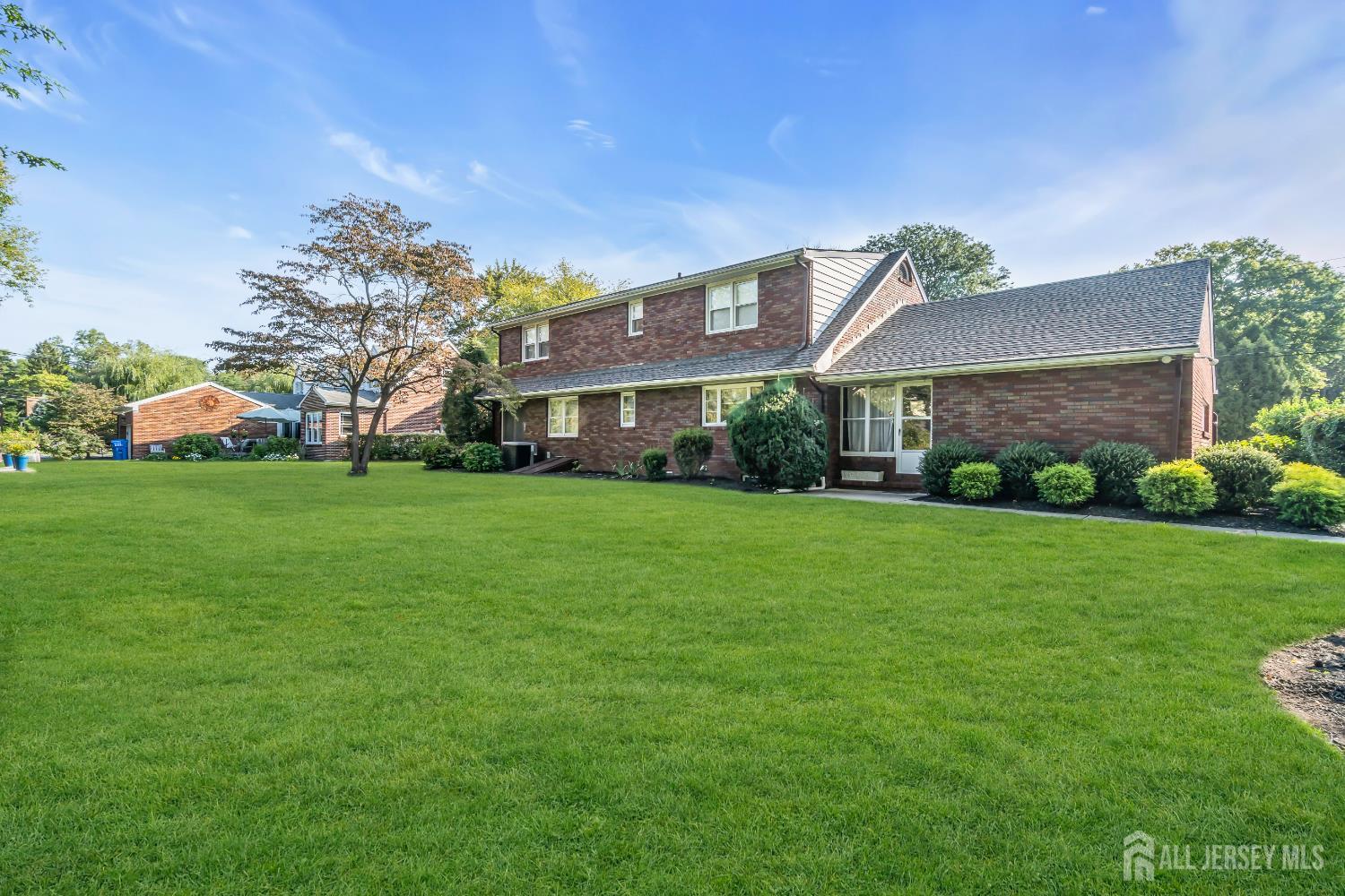 16 Stafford Road Colonia, NJ 07067 - Photo 38 of 41 a view of a house next to a big yard with plants and large trees
