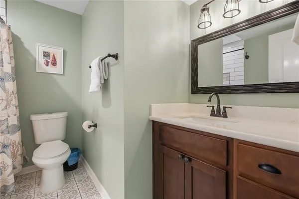 a bathroom with a toilet and a shower curtain
